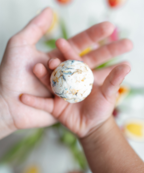 Natava vadvirágos fürdőgolyó egy gyermek kezében