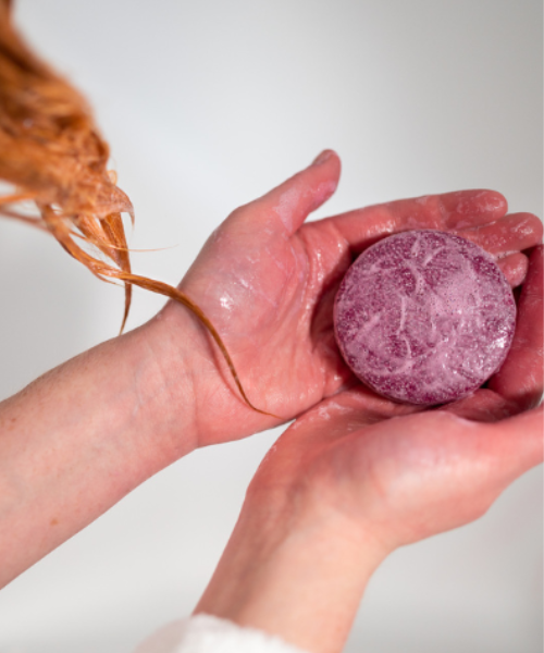 Natava ylang-ylang szilárd sampon egy nő kezében